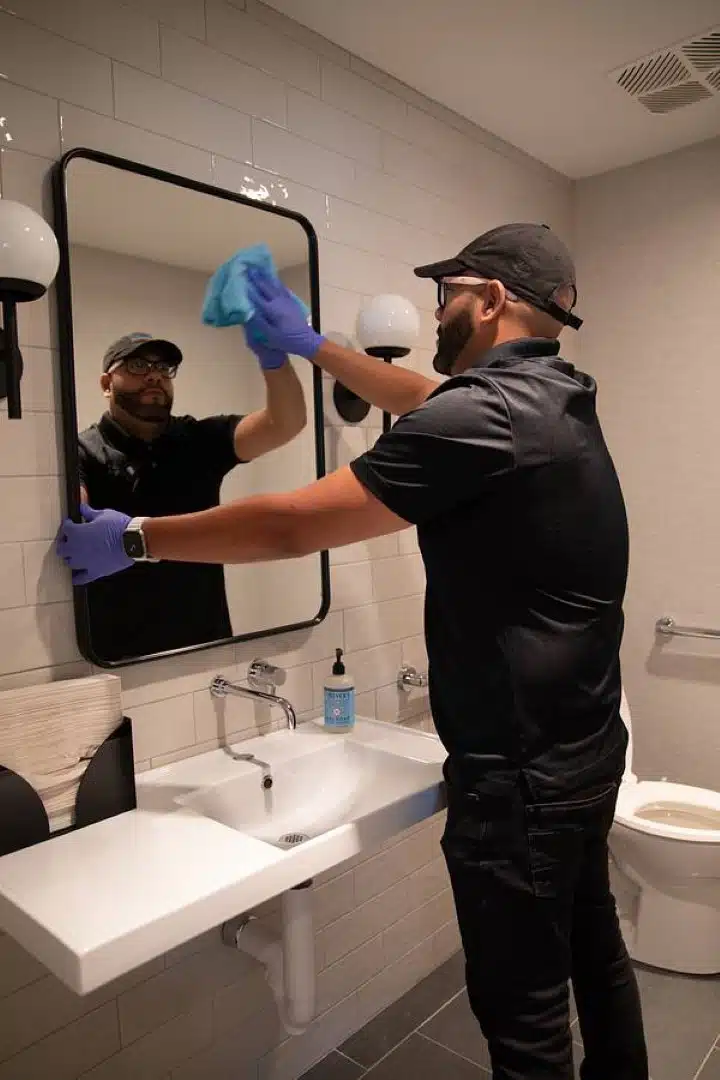 Helping Hand Commercial Cleaning Staff Cleaning Mirror