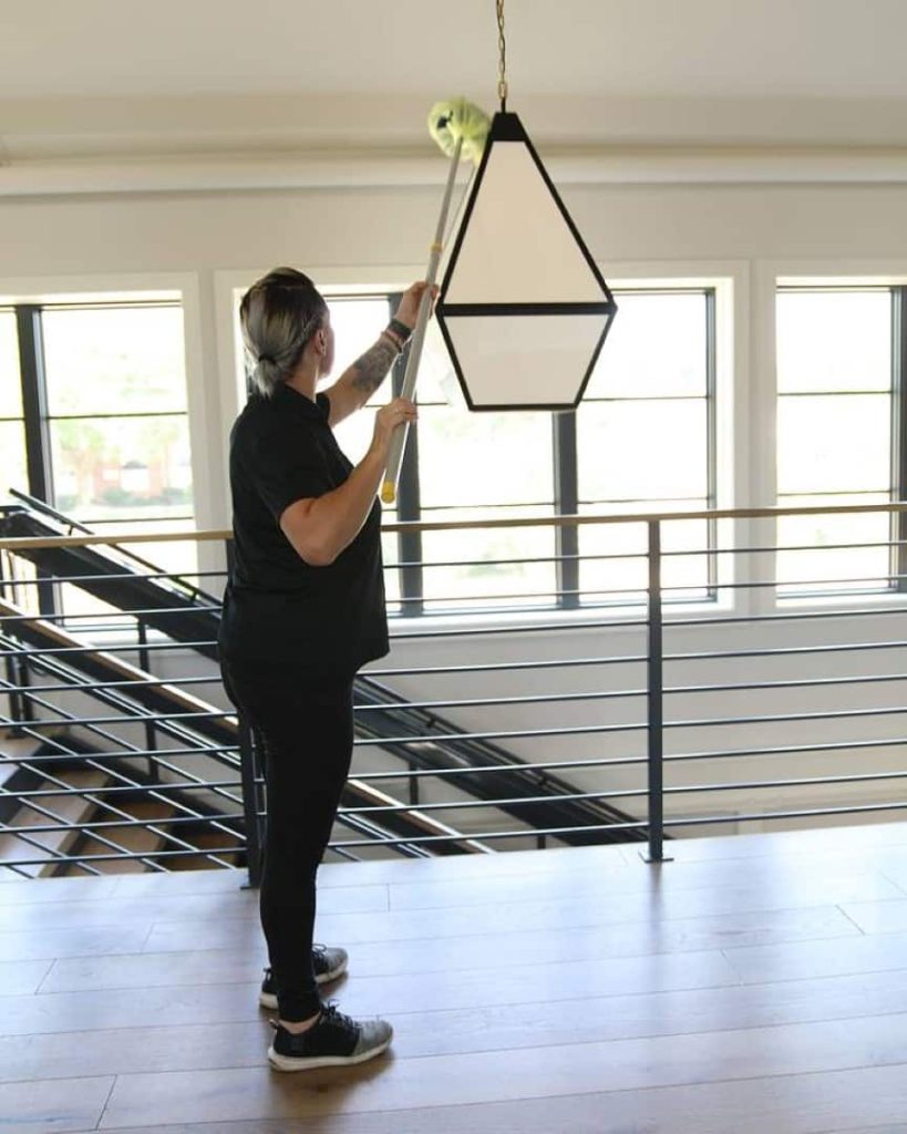 professional commercial cleaner dusting ceiling light as a janitorial service in Chicago